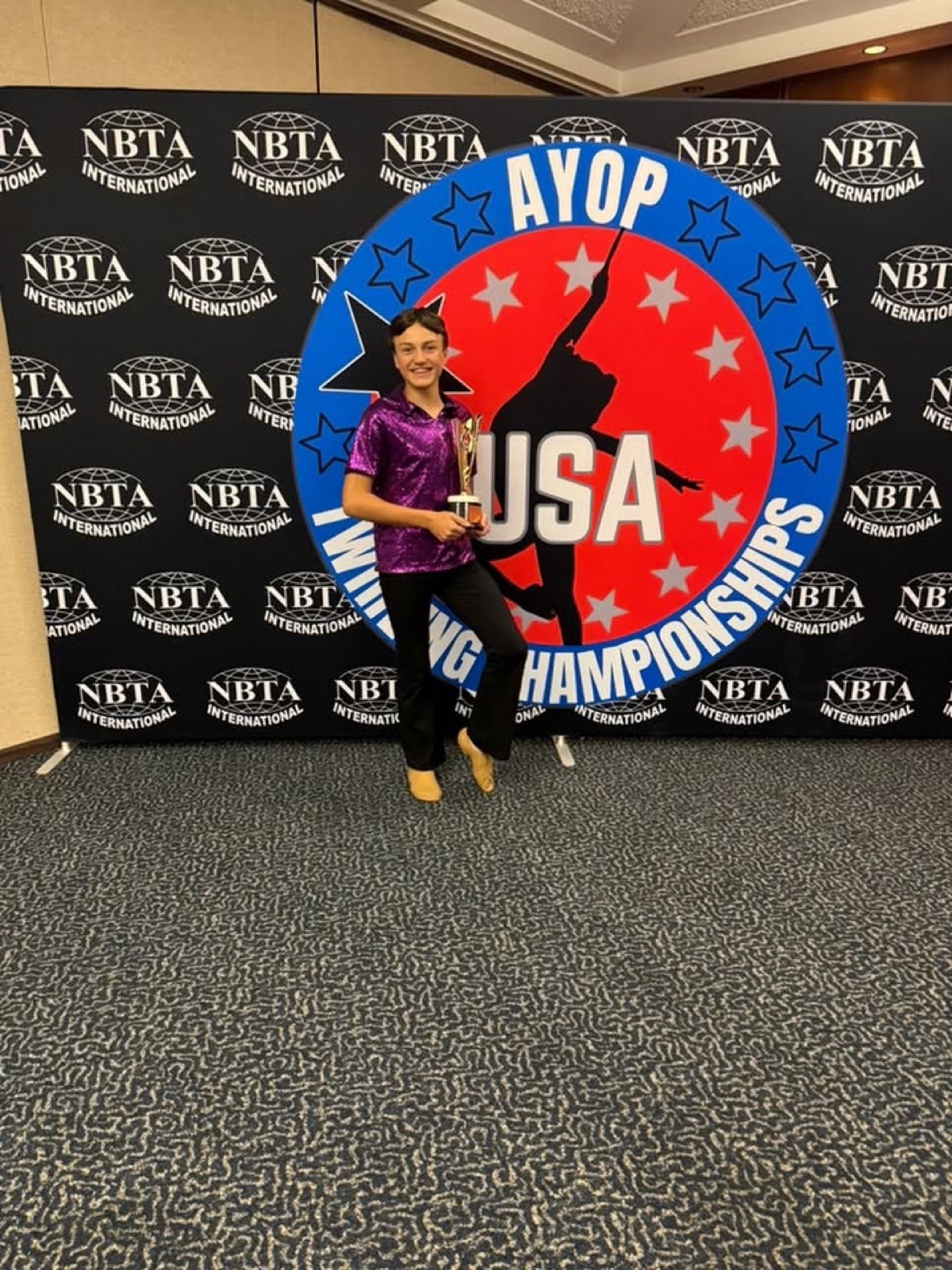 Captivators twirler with a championship trophy